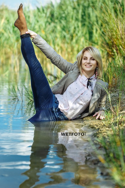 blonde wet girl swim fully clohed wet hair blouse skinny jeans jacket high heels lake