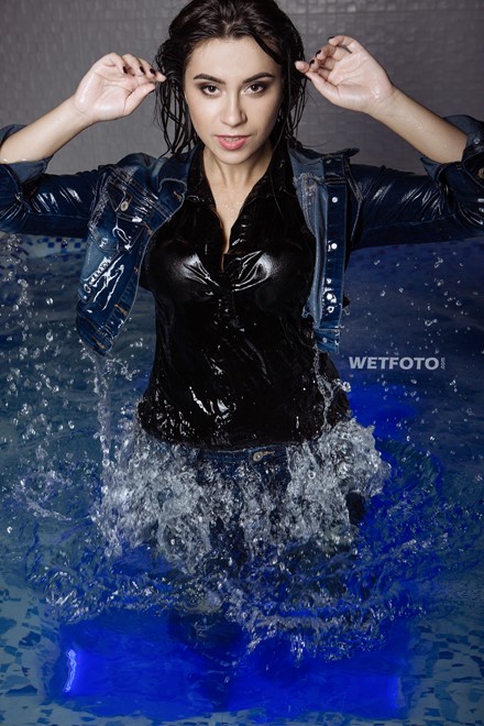 wetlook girl with wet jeans clothing enjoying the water takes a shower swims in pool