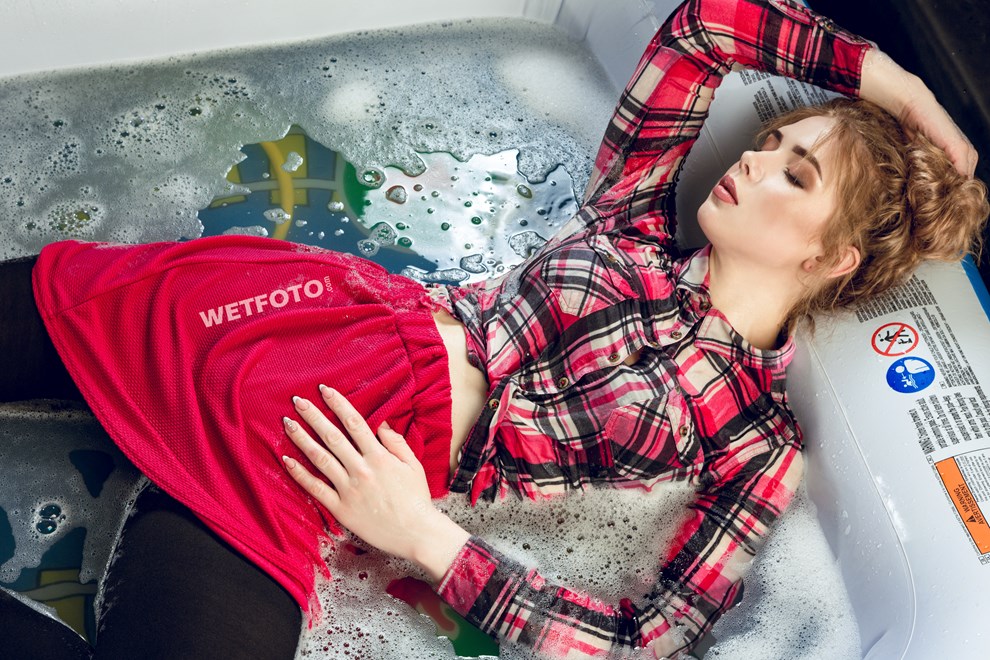 wetfoto wetlook girl in wet clothes lying in the pool full of water