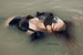 girl swims in lake business suit nylons